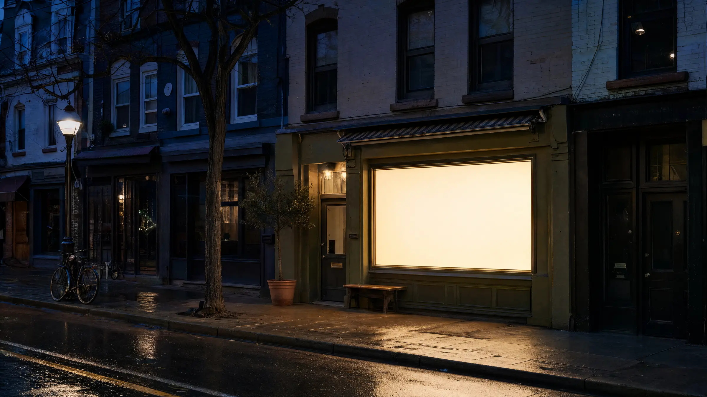 A café window glowing warm on a wet Toronto street at night